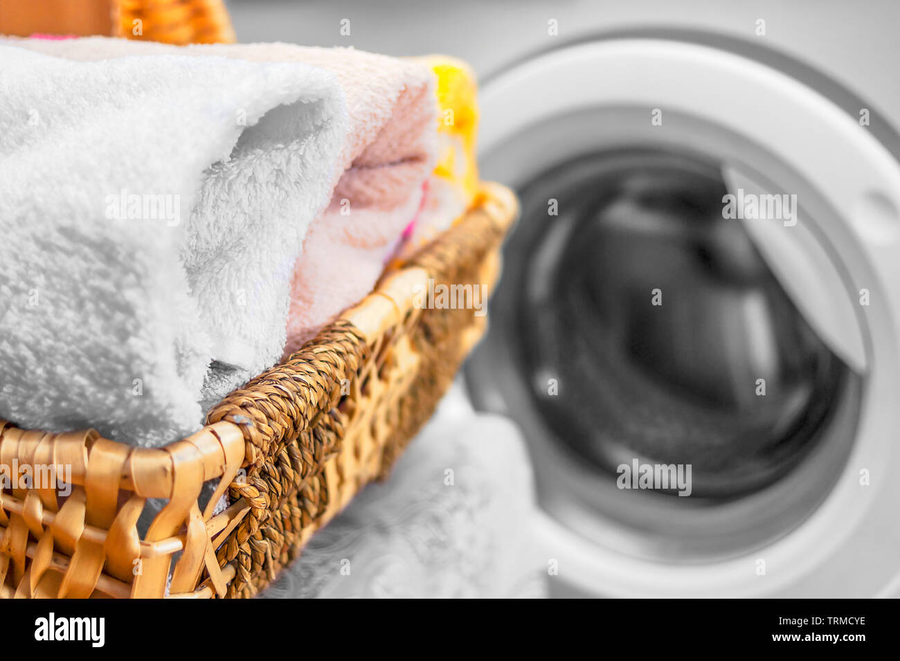 Wicker Basket with Clean Towels near the Front Load Washing Machine
