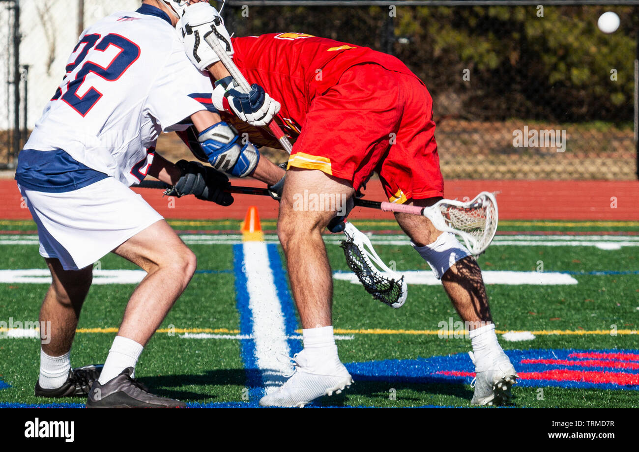 A lacrosse stick hits opponent in the crotch as they fight for the ball