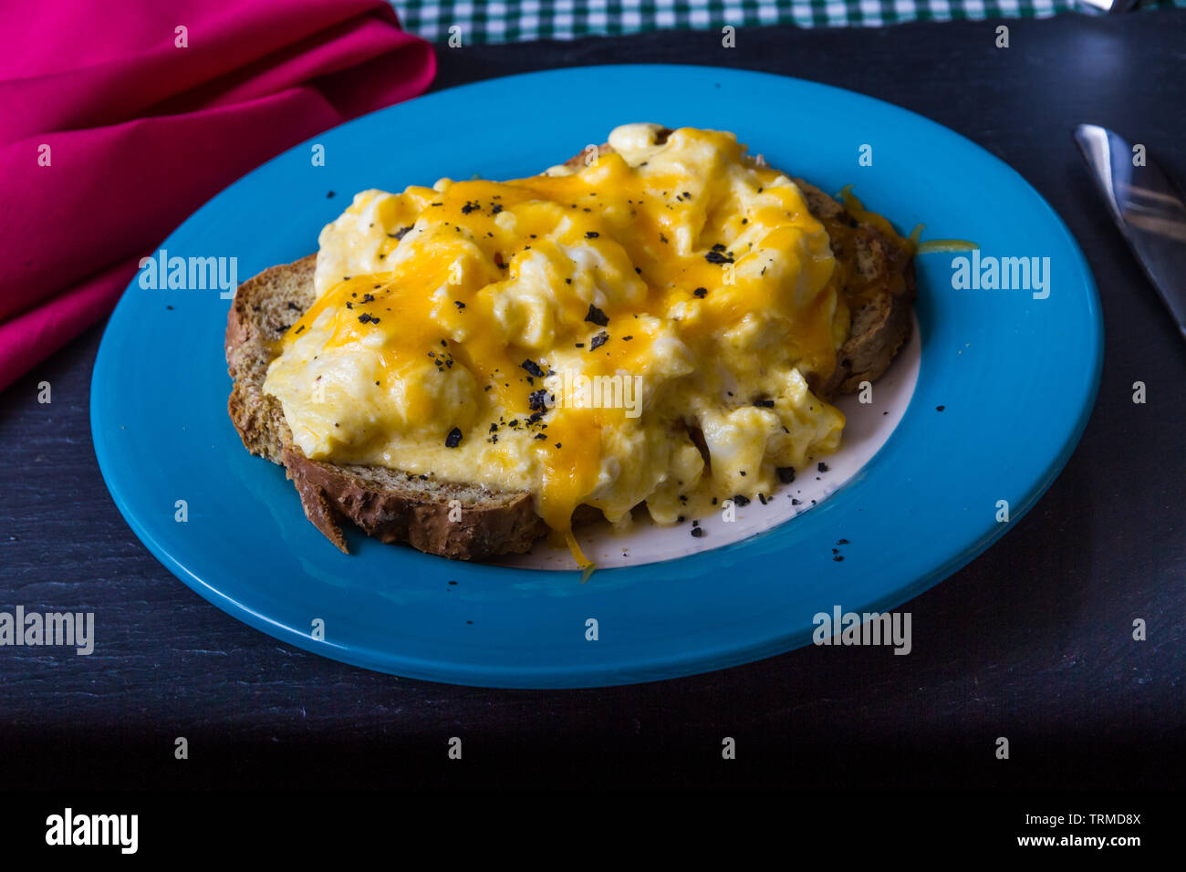 Scrambled eggs with melted grated cheese on toast, breakfast or brunch ...