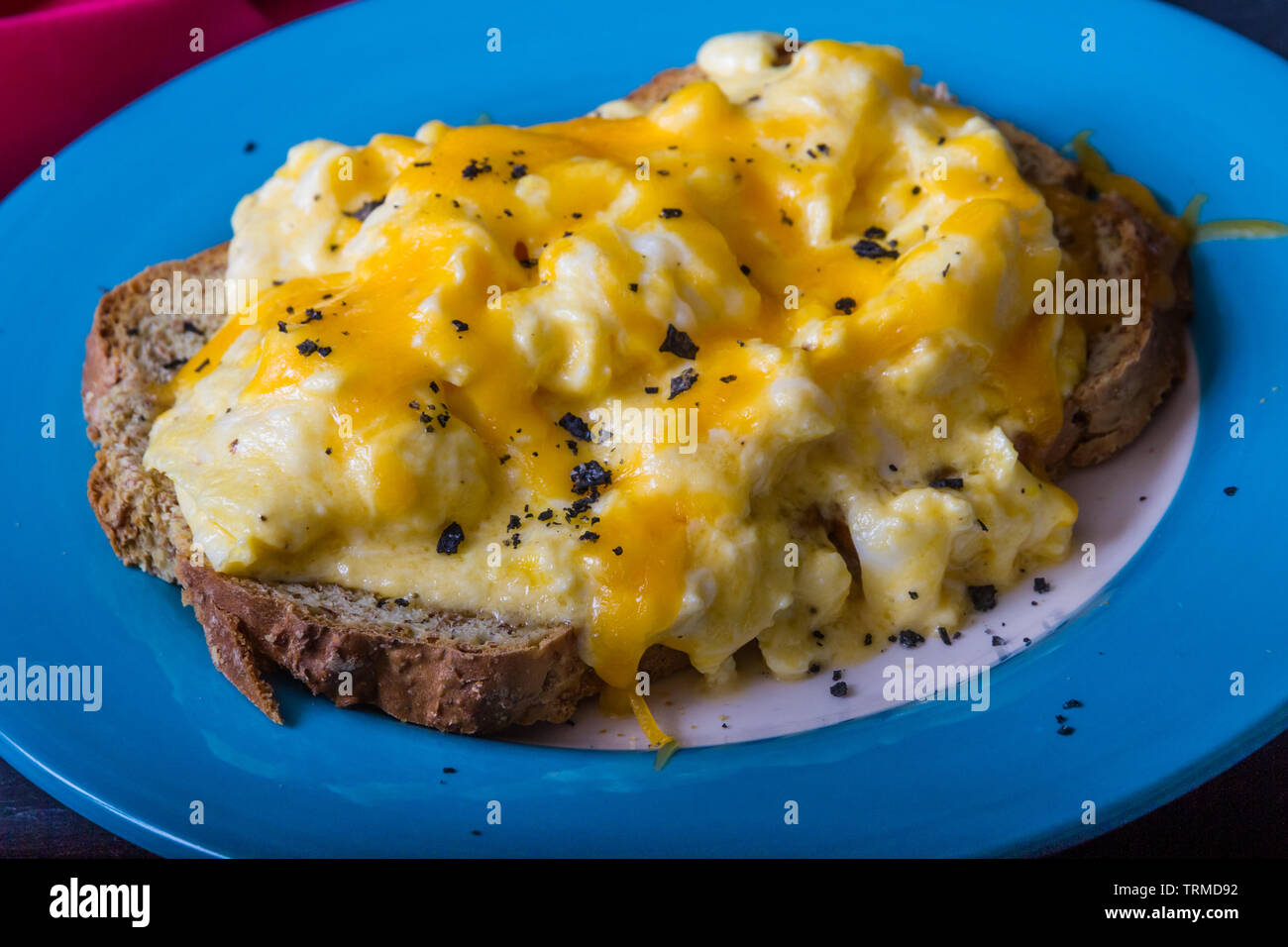 Scrambled Eggs With Melted Grated Cheese On Toast Breakfast Or Brunch Topped With Charcoal Salt Stock Photo Alamy