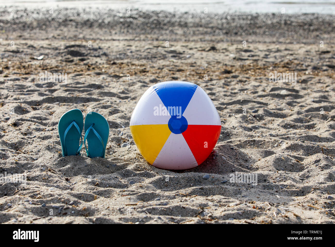 Flip flops on beach sand with beach ball Stock Photo - Alamy