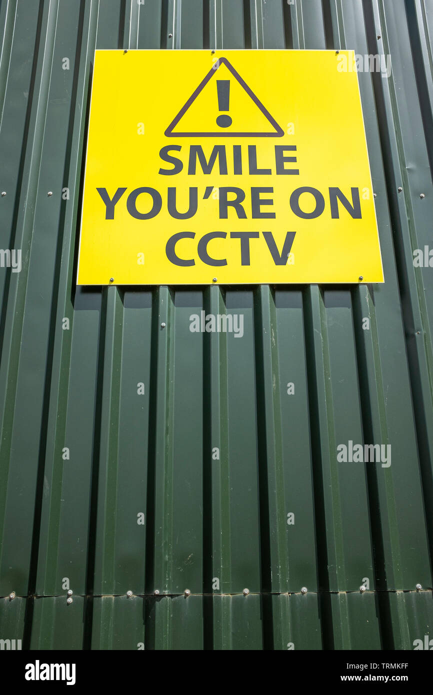 Smile you're on CCTV friendly request sign on industrial unit UK Stock Photo