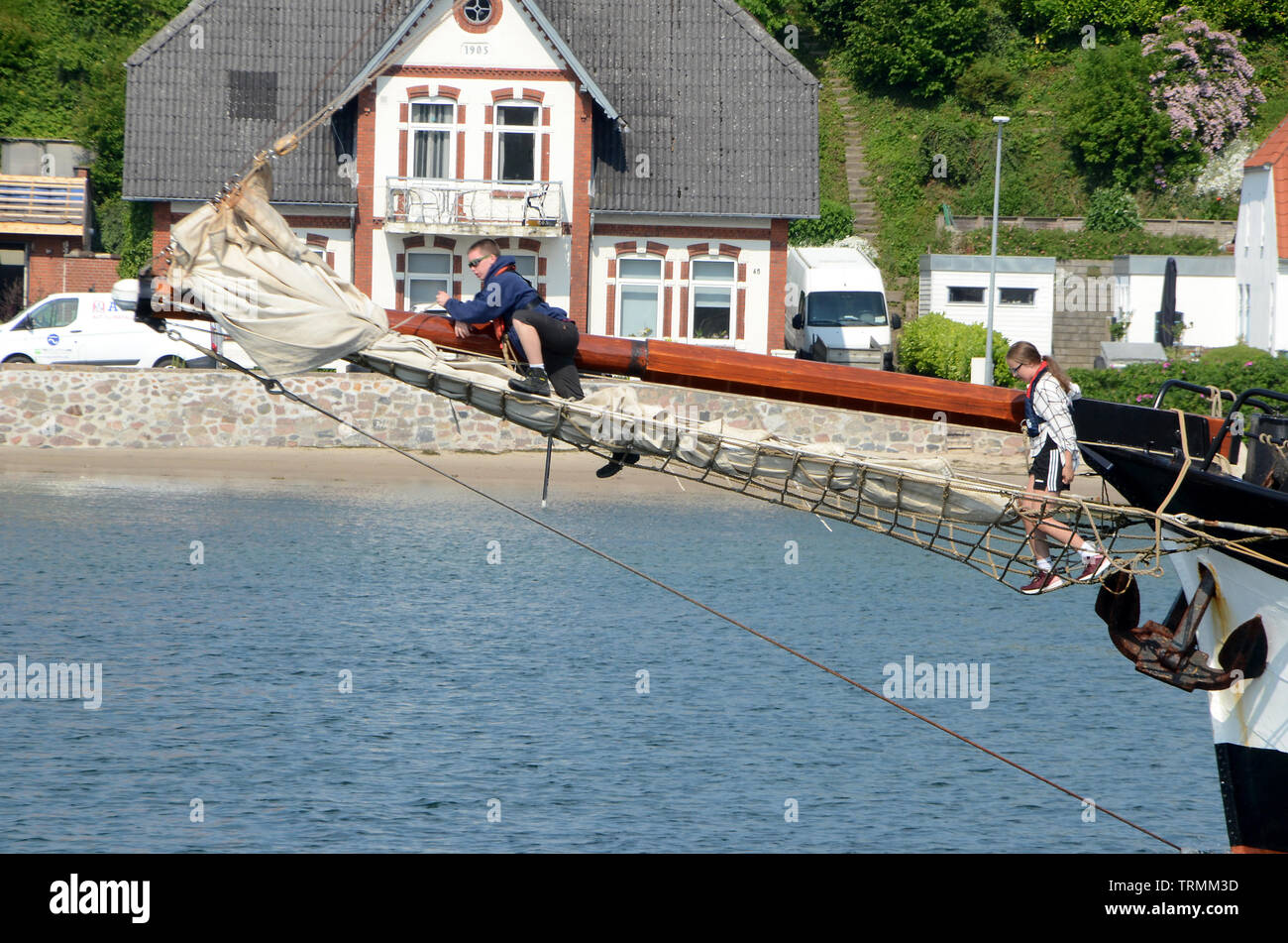 Sonderborg, Denmark - June 5, 2019: Two teenagers climb in the bowsprit net of the cruise ship Pegasus Stock Photo