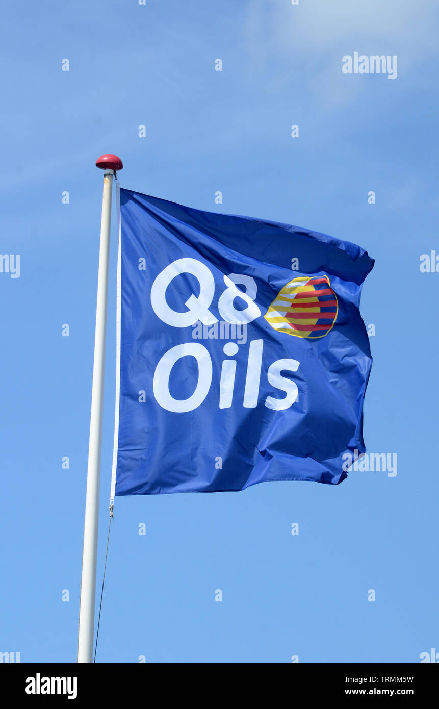 Sonderborg, Denmark - June 7, 2019: Blue Q8 Oils flag blow in the wind with a blue sky as background Stock Photo