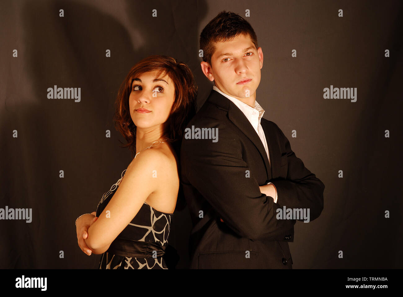 Young couple back to back, crossing arms Stock Photo Alamy