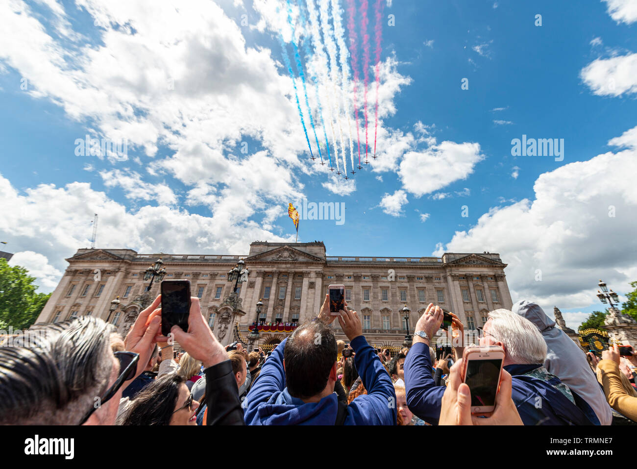 The Royal Air Force Red Arrows passing over Buckingham Palace for the Queen's Birthday Flypast 2019 with crowds. London, UK Stock Photo