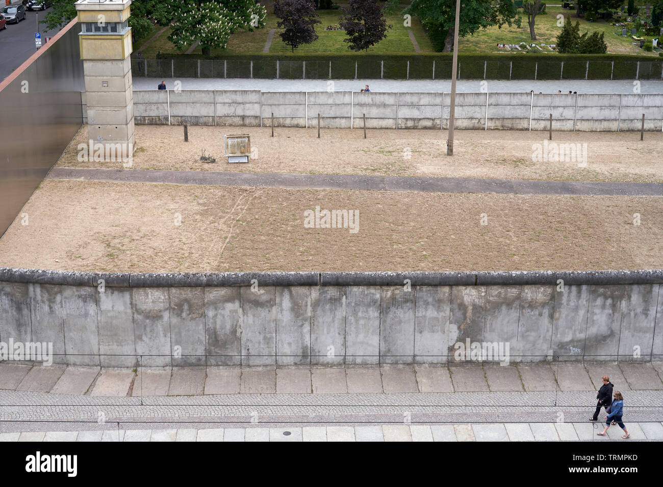 A couple walks next to one of the longest remnants of the Berlin Wall