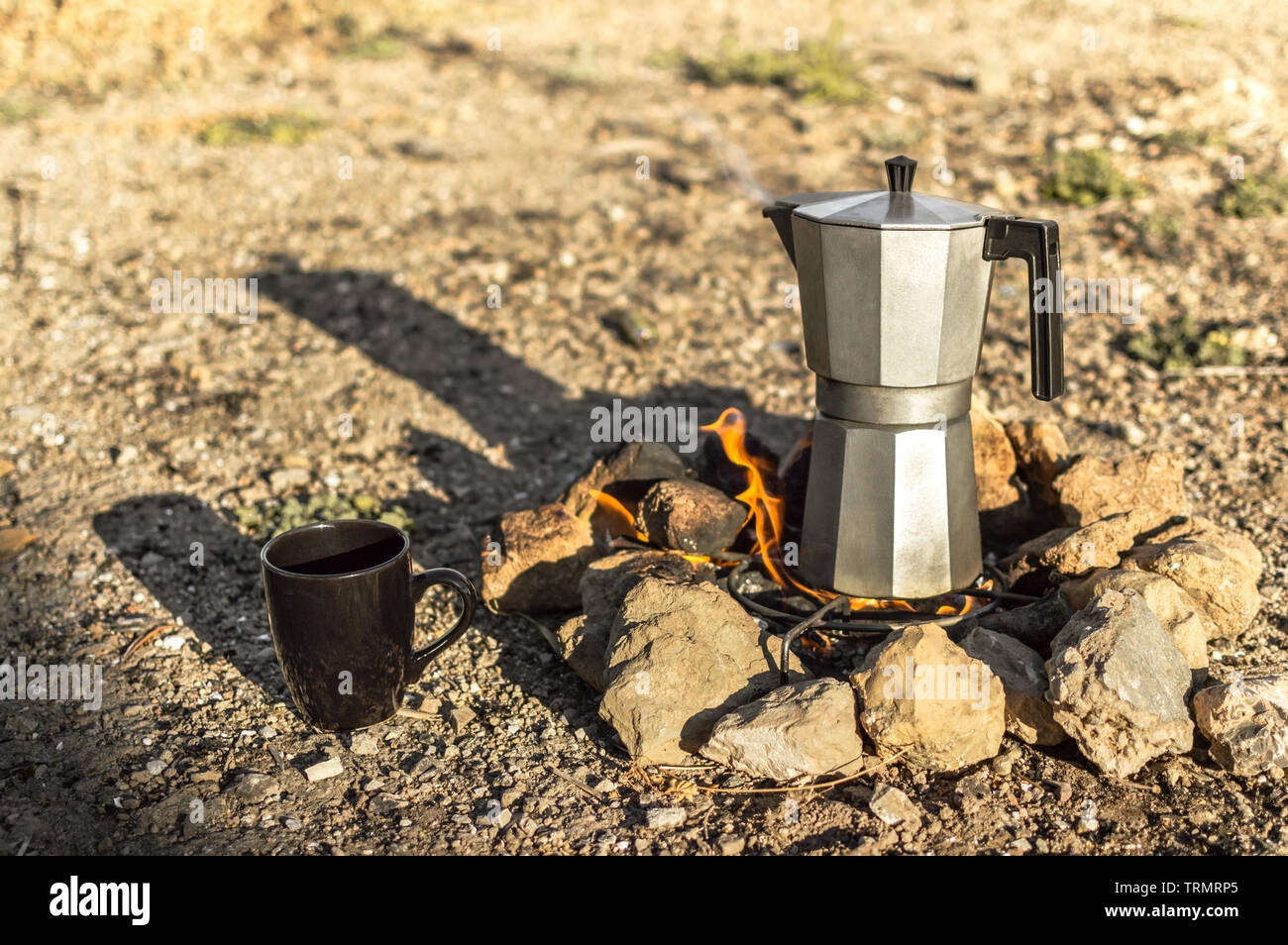 Preparing coffee with bonfire and moka pot coffee maker resting during a camp in nature. Overhead view of firewood burning cup and coffee machine Stock Photo Alamy