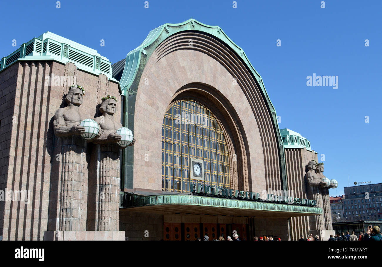 HELSINKI, FINLAND - 6 APRIL 2019: Main entrance to Eliel Saarine's Central Station with stone guardians suppporting lights. Stock Photo