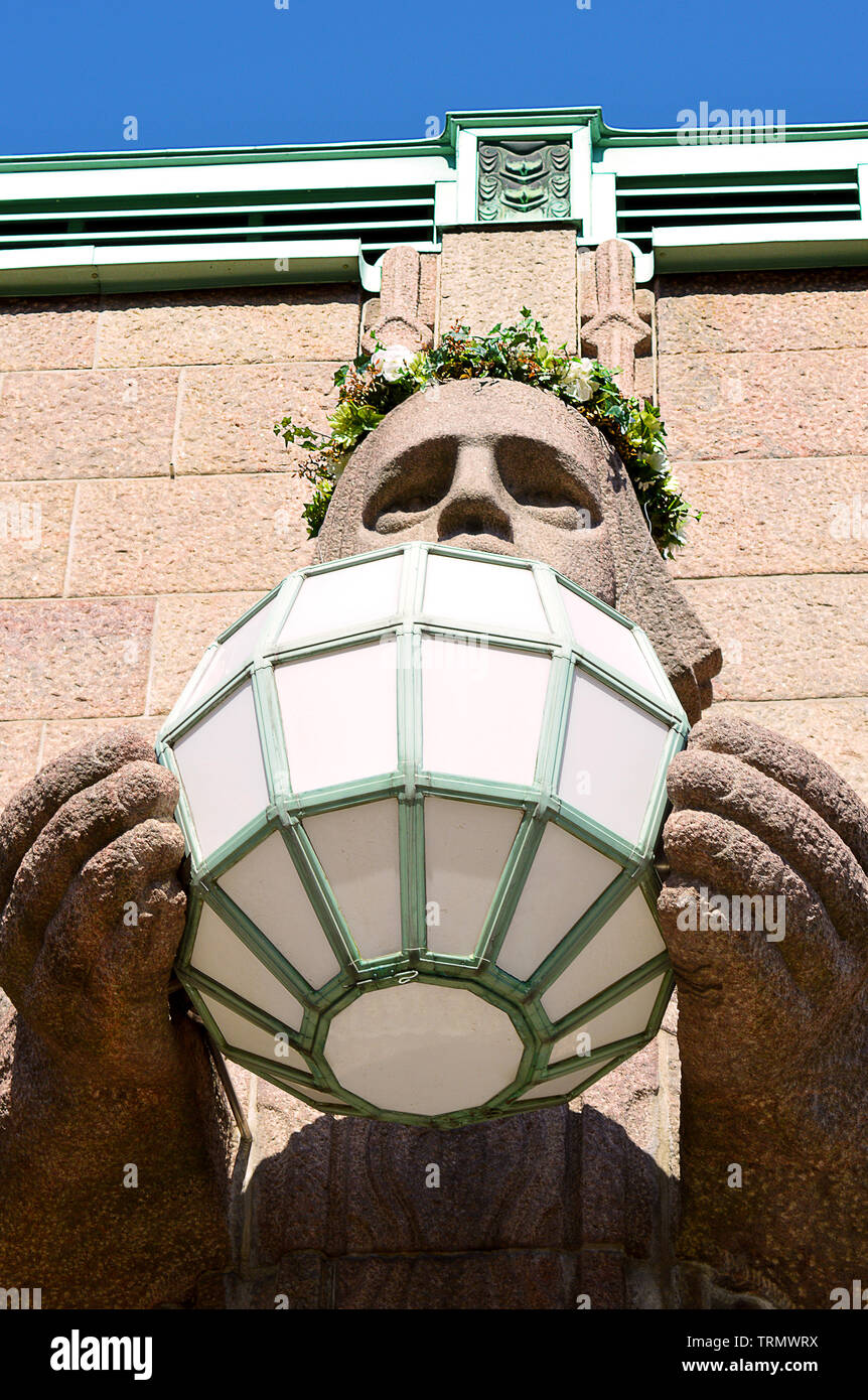HELSINKI, FINLAND - 6 APRIL 2019: One of the stone guardians used to support lights at the main entrance to Eliel Saarine's Central Station wih a flow Stock Photo