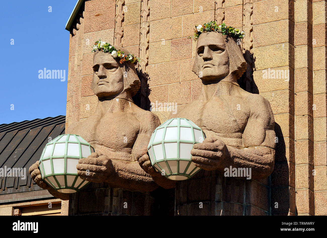HELSINKI, FINLAND - 6 APRIL 2019: Two of the stone guardians used to support lights at the main entrance to Eliel Saarinen's Central Station. Stock Photo