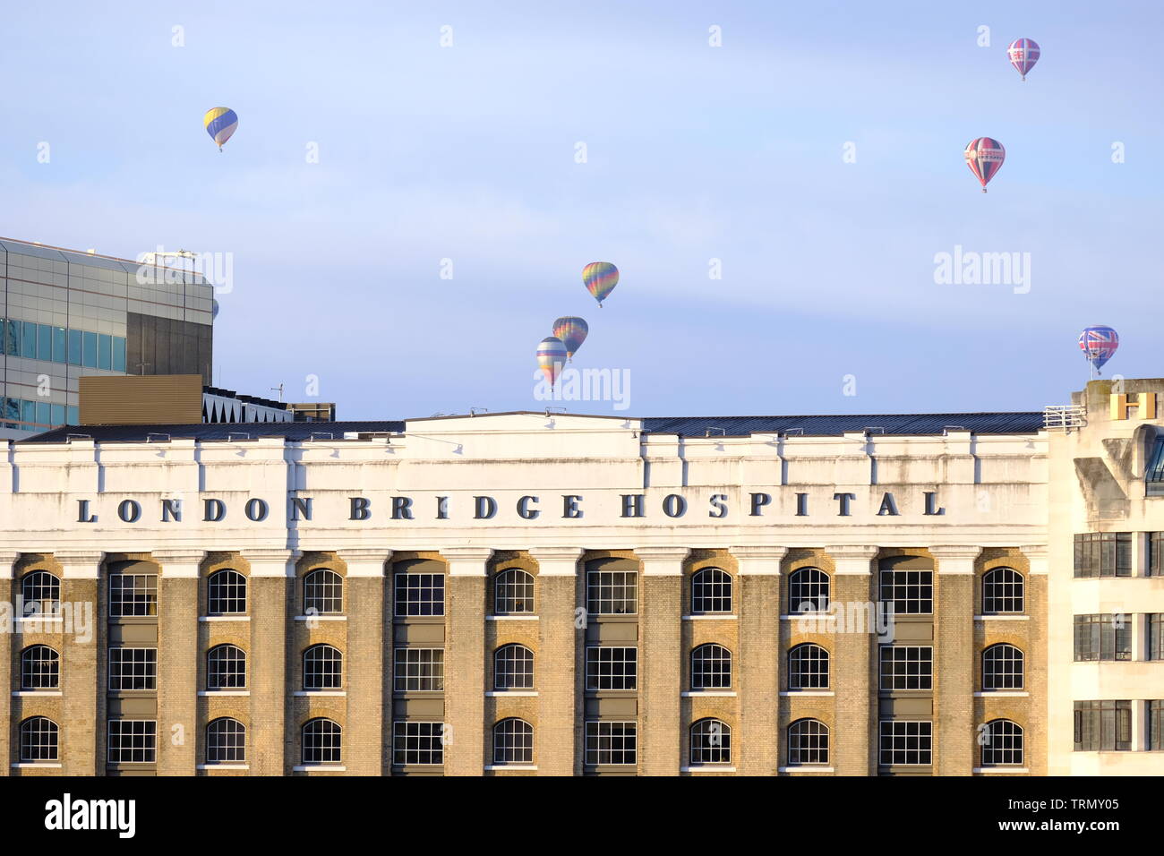 The floatilla from the RICOH Lord Mayor of London's Hot Air Balloon Regatta 2019 passes over London Bridge Hospital early on a Sunday morning. Stock Photo