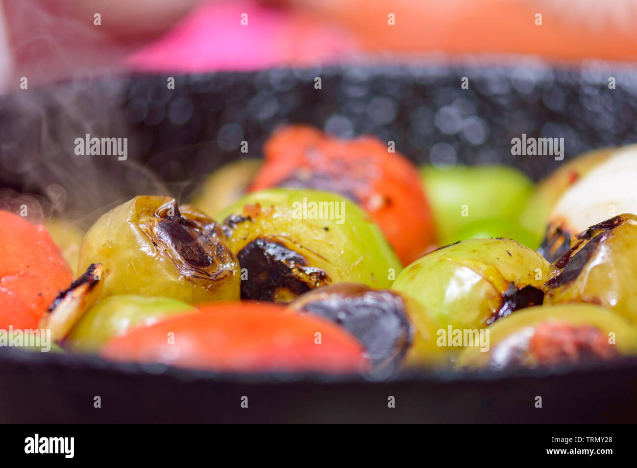 Cooking Mexican green sauce, salsa verde, made with tomatillos, tomatoes, onions, garlic chiles