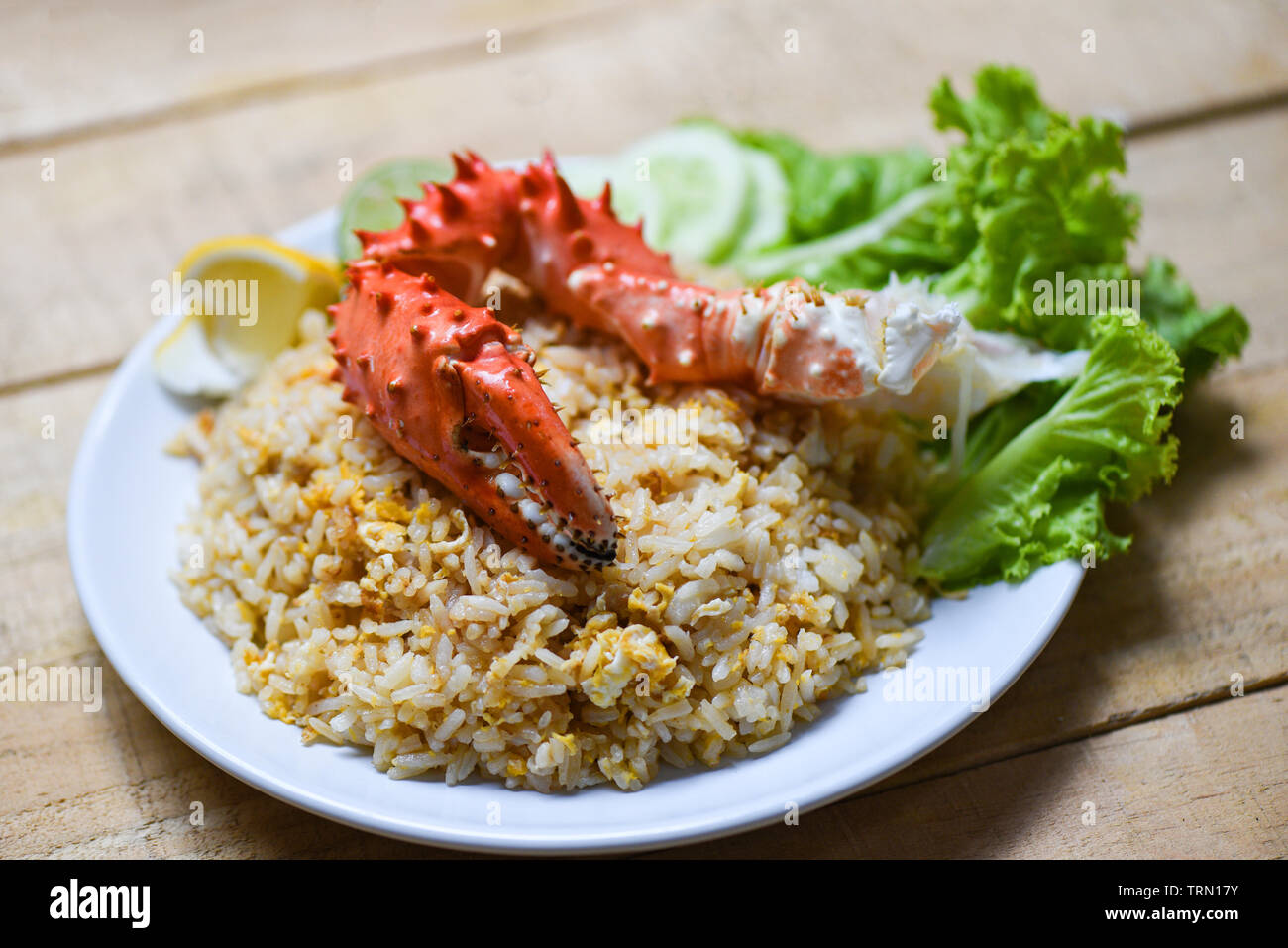 Fried Rice crab seafood egg lemon and cucumber on white plate wooden