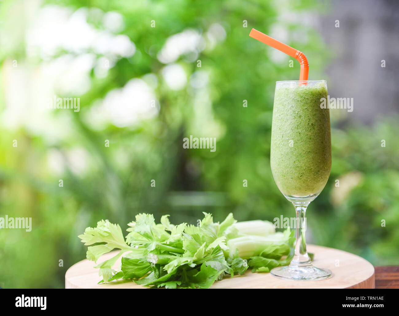 Vegetable juice smoothie summer and fresh celery stalk on wooden board with  nature green background Stock Photo - Alamy