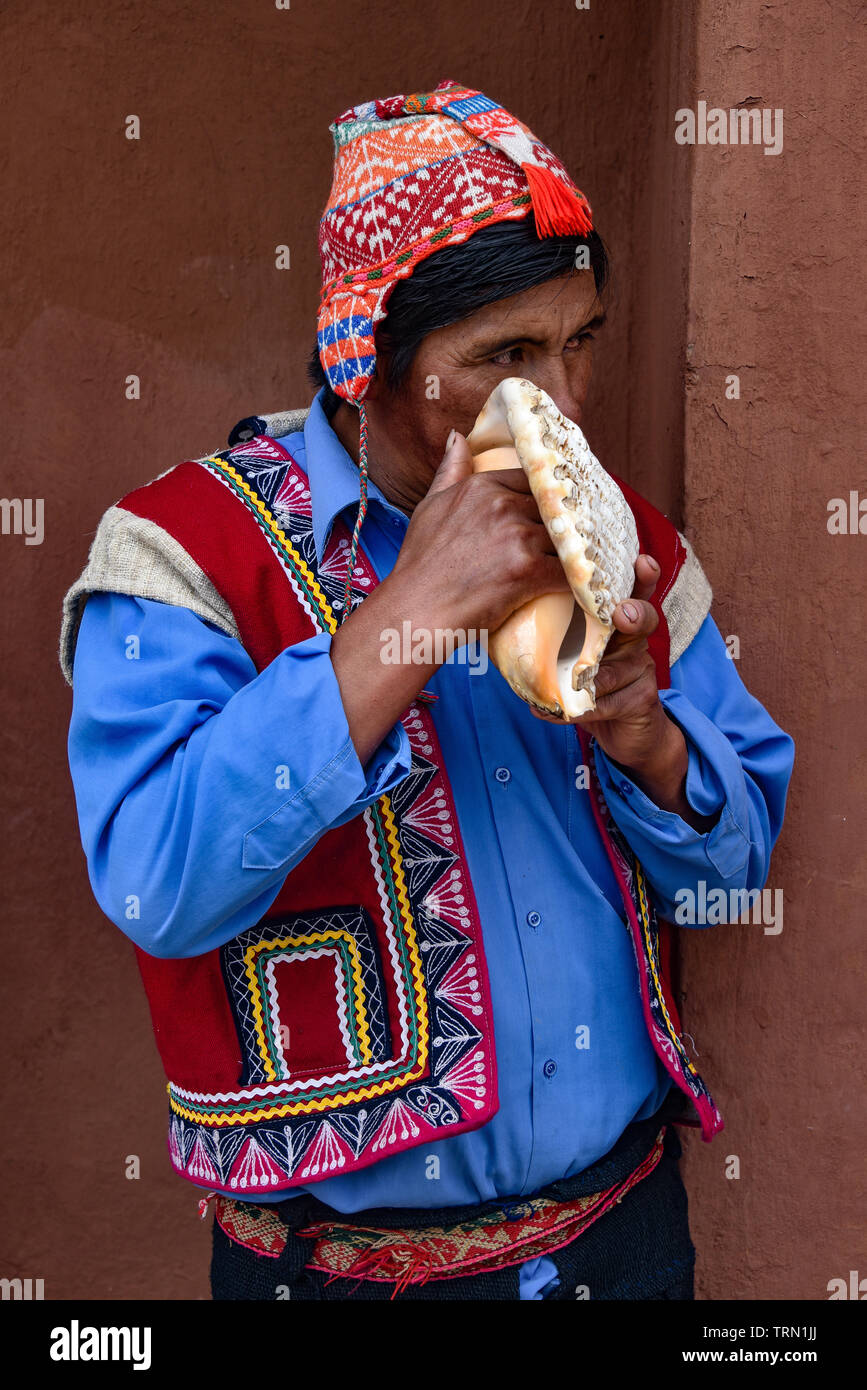 Sacred Valley, Cusco, Peru - Oct 13, 2018: An indigenous Quechua man blows on a Conch Shell Stock Photo