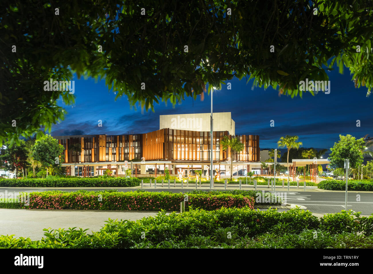 View through gardens to the Cairns Performing Arts Centre at twilight, Cairns, Queensland, Australia Stock Photo