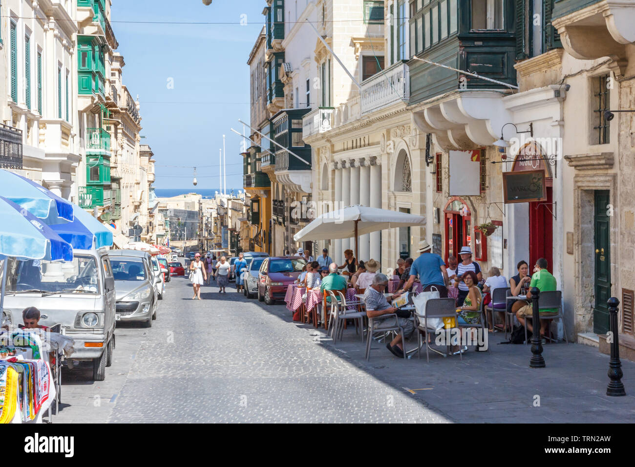 Valetta, Malta - September 13th 2015: Tourists sat outside on the main street. The city is a popular port with cruise ships. Stock Photo