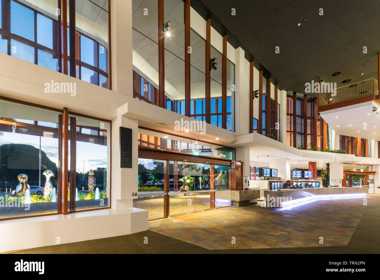 The foyer of the Cairns Performing Arts Centre illuminated at twilight ...