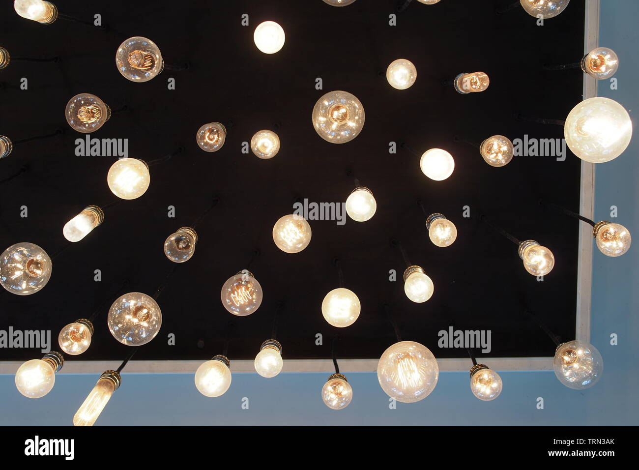 Detail of a light fixture made of dozens of different style bulbs (bare
