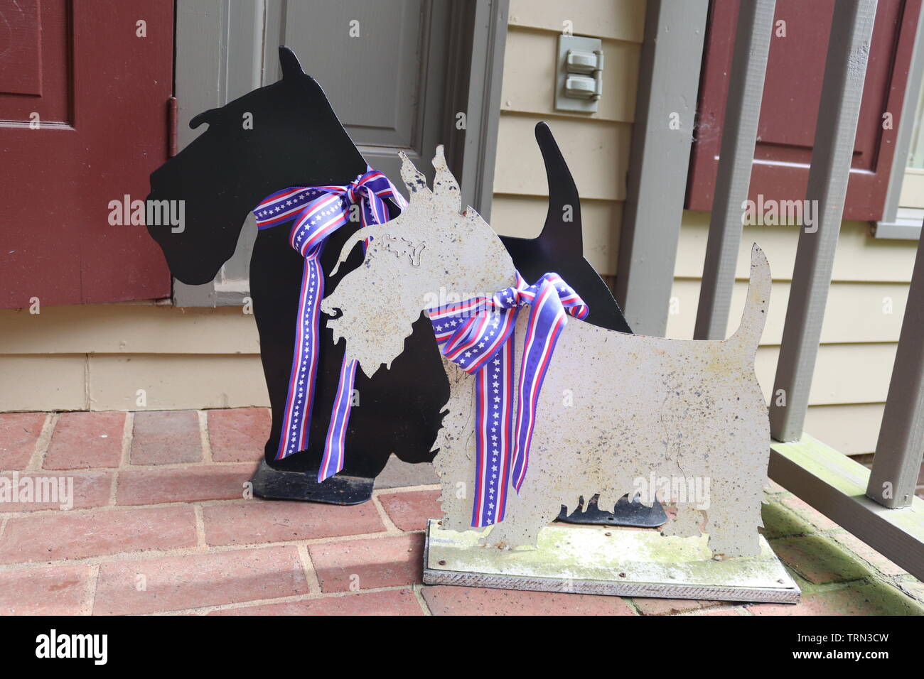 Two Scottish Terrier metal cutouts on a porch. Stock Photo