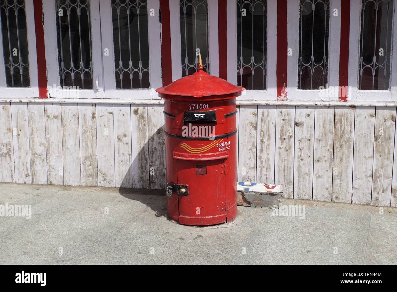 Isolated, Red India Post Mailbox against a Redand White Background Stock Photo