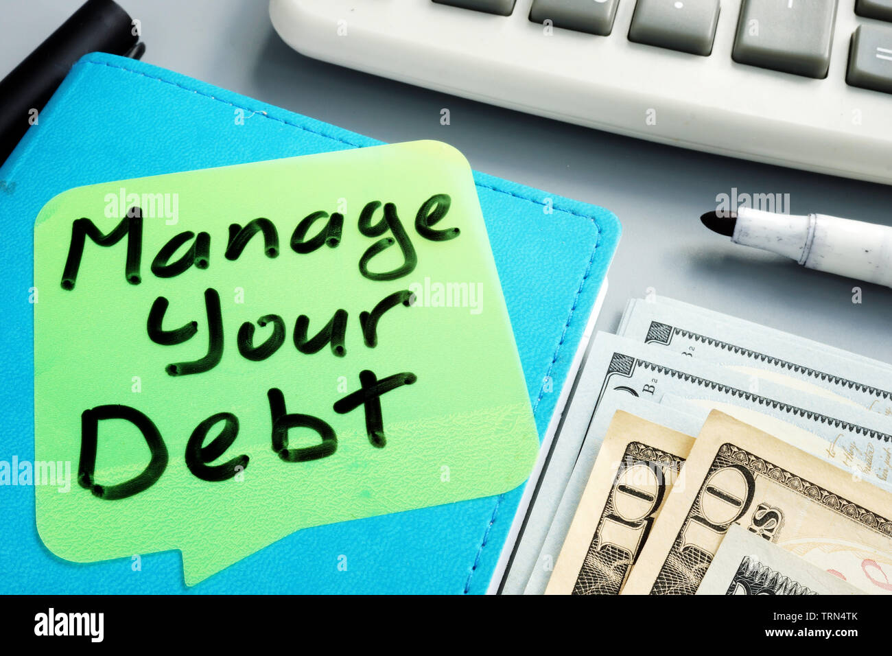 Manage your debt sign. Book and cash. Stock Photo