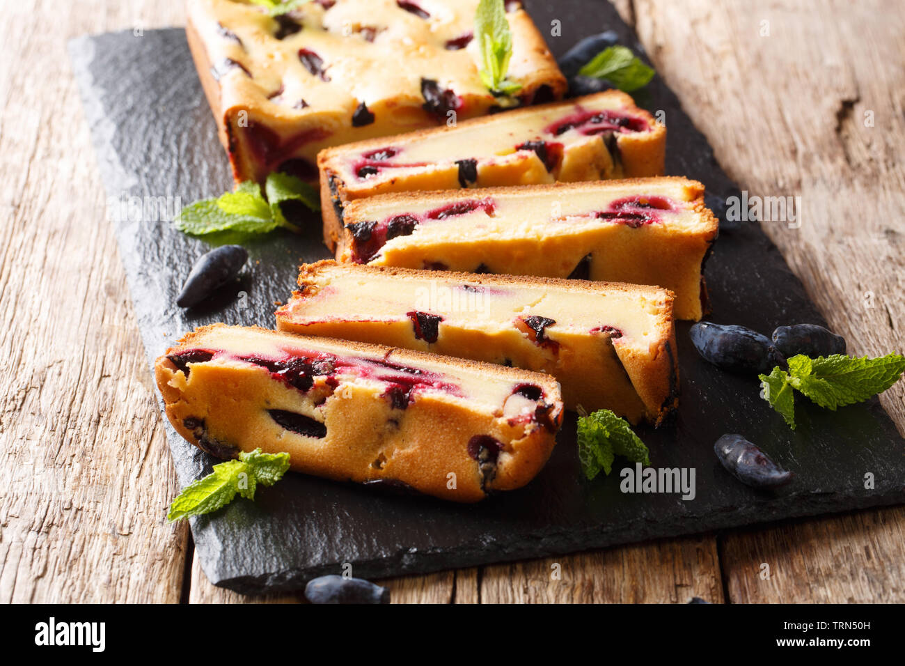 Homemade bread with honeysuckle and mint on the board closeup on a wooden table. horizontal Stock Photo