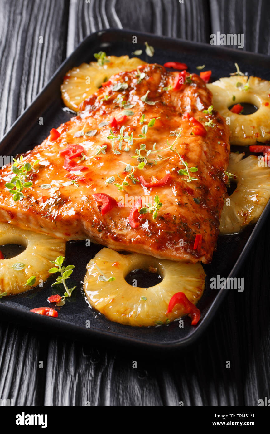 Red fish fillet baked with pineapple in chili sweet sauce closeup on a