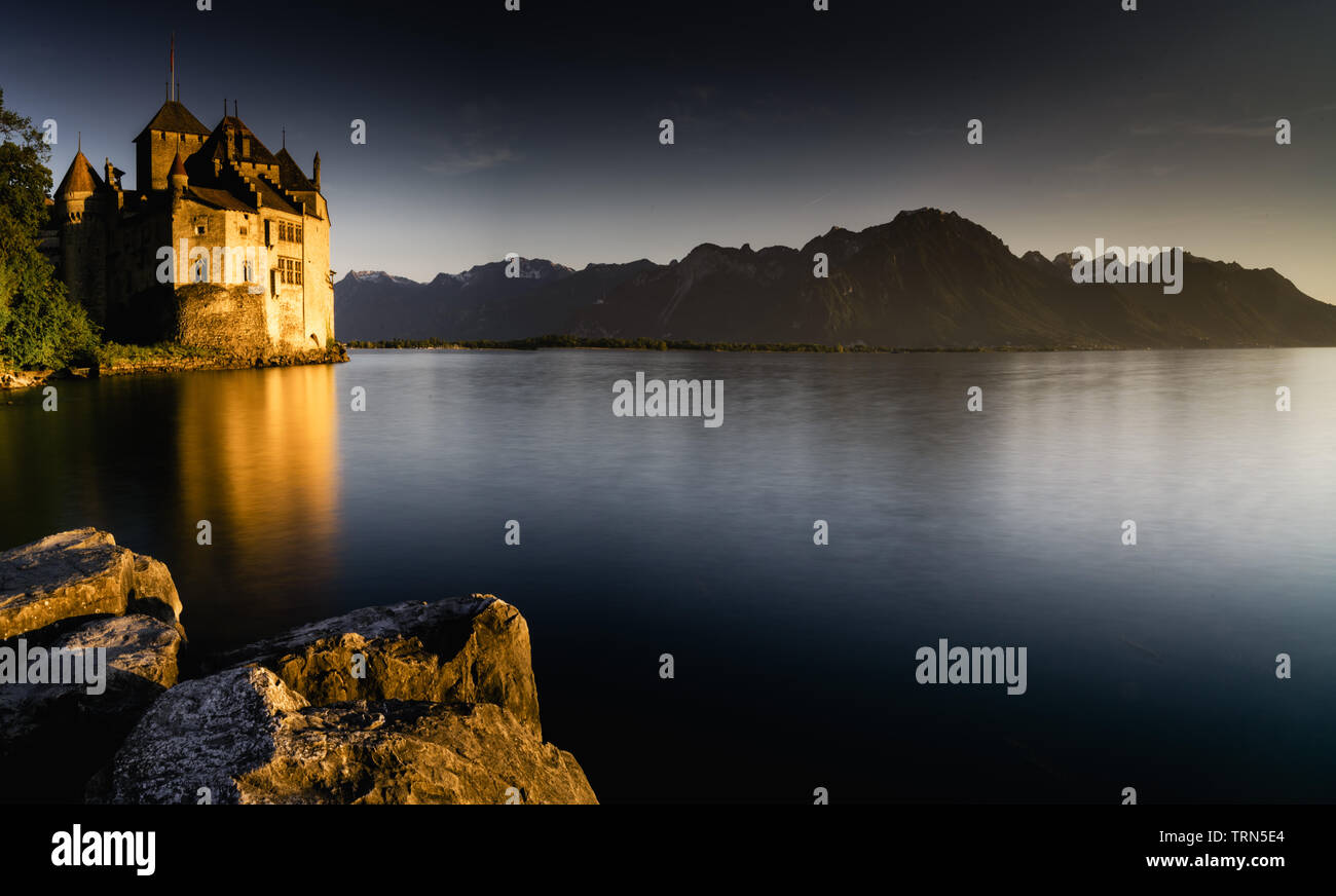 Montreux, VD / Switzerland - 31 May 2019: the historic Chillon Castle on the shores of Lake Geneva at sunset Stock Photo