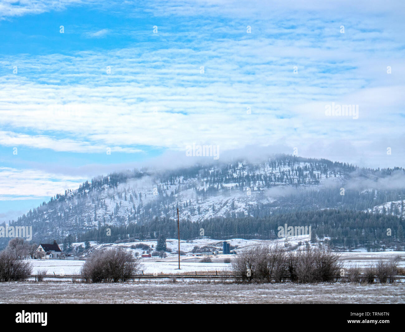 Chewelah Washington USA Farm Land Mountain Backdrop Snowy Winter Day Under Blue Sky Cloud Cover Stock Photo