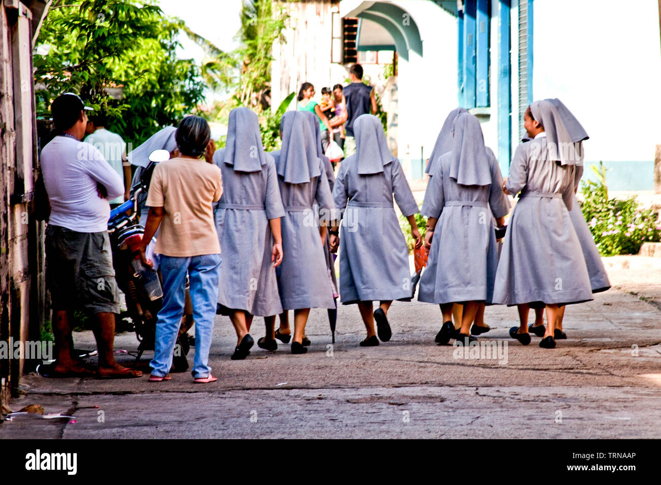 Nuns of the order of St. Paul walk to the Immaculate Conception Church for afternoon mass. They assist in the townspeople needs and education. Stock Photo
