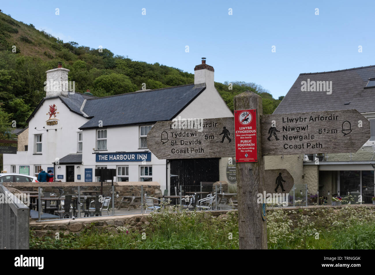 The Harbour Inn and a Pembrokeshire coast path signpost in Solva, Pembrokeshire, Wales, UK Stock Photo