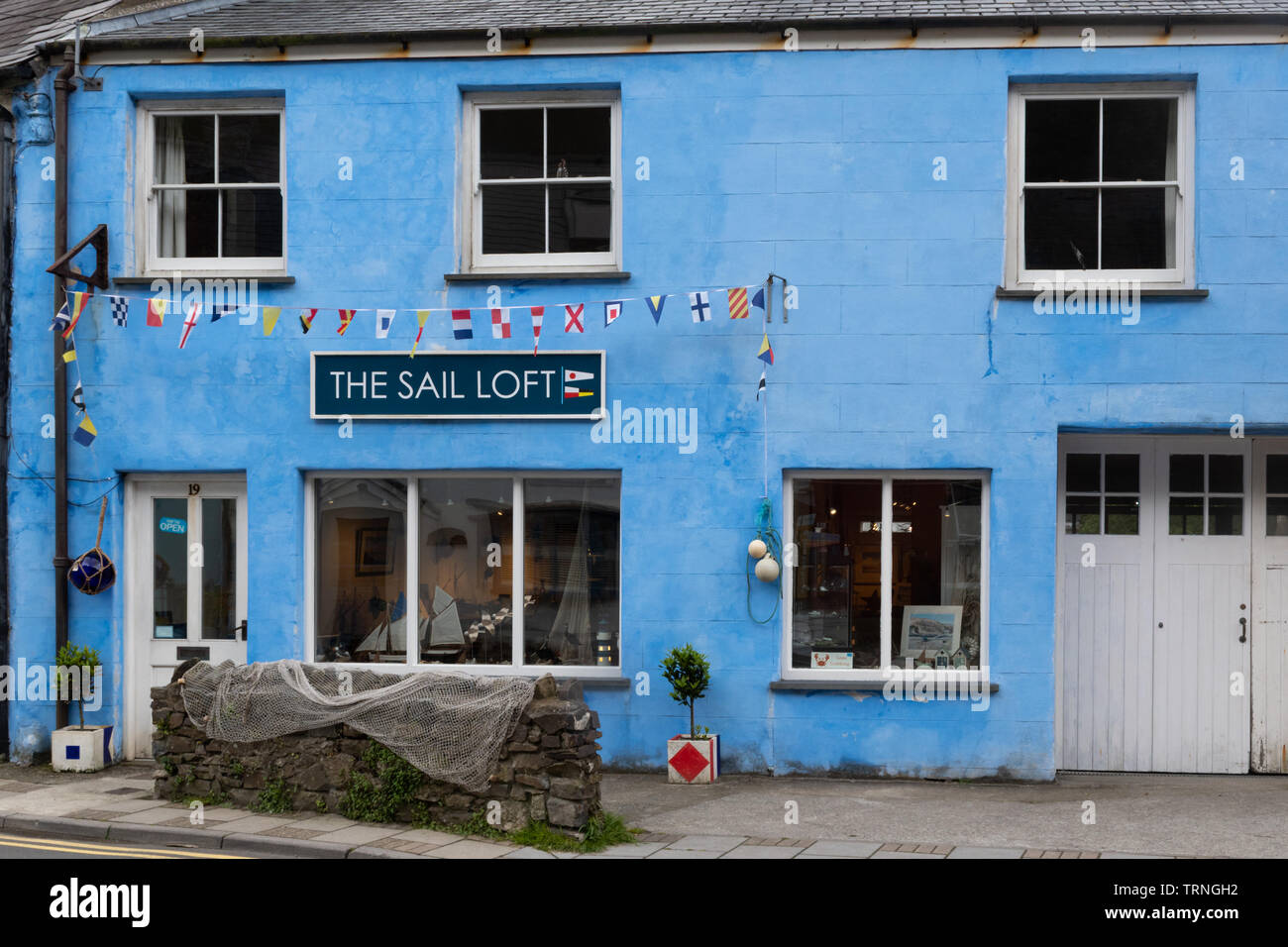 The Sail Loft Gallery and apartment, originally used for storing sails, now painted bright blue, in the conservation area of Solva, Pembrkeshire Wales Stock Photo