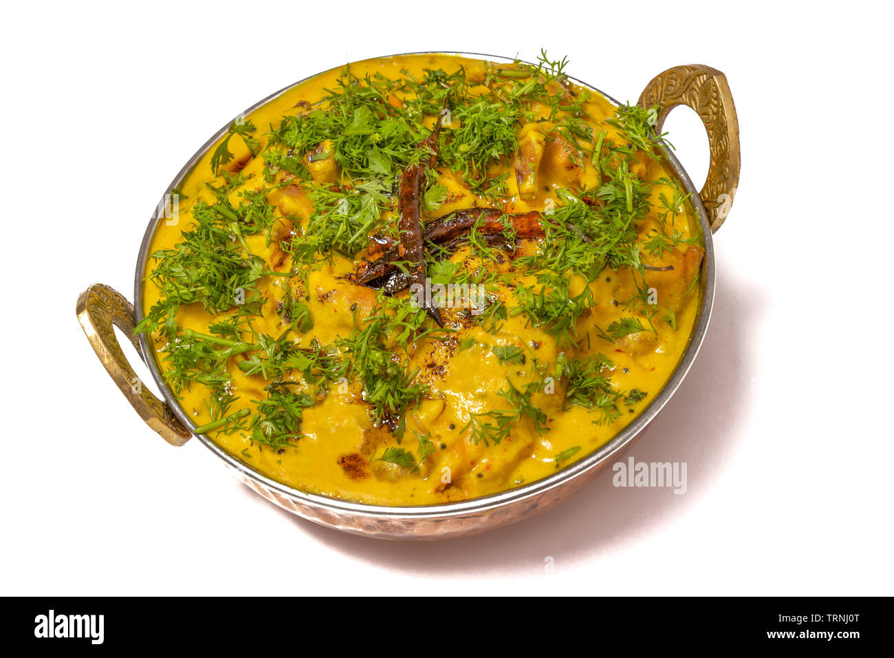 Kadhi Pakoda or pakora, Indian cuisine, served in a brass kadai or bowl isolated on white background. Stock Photo