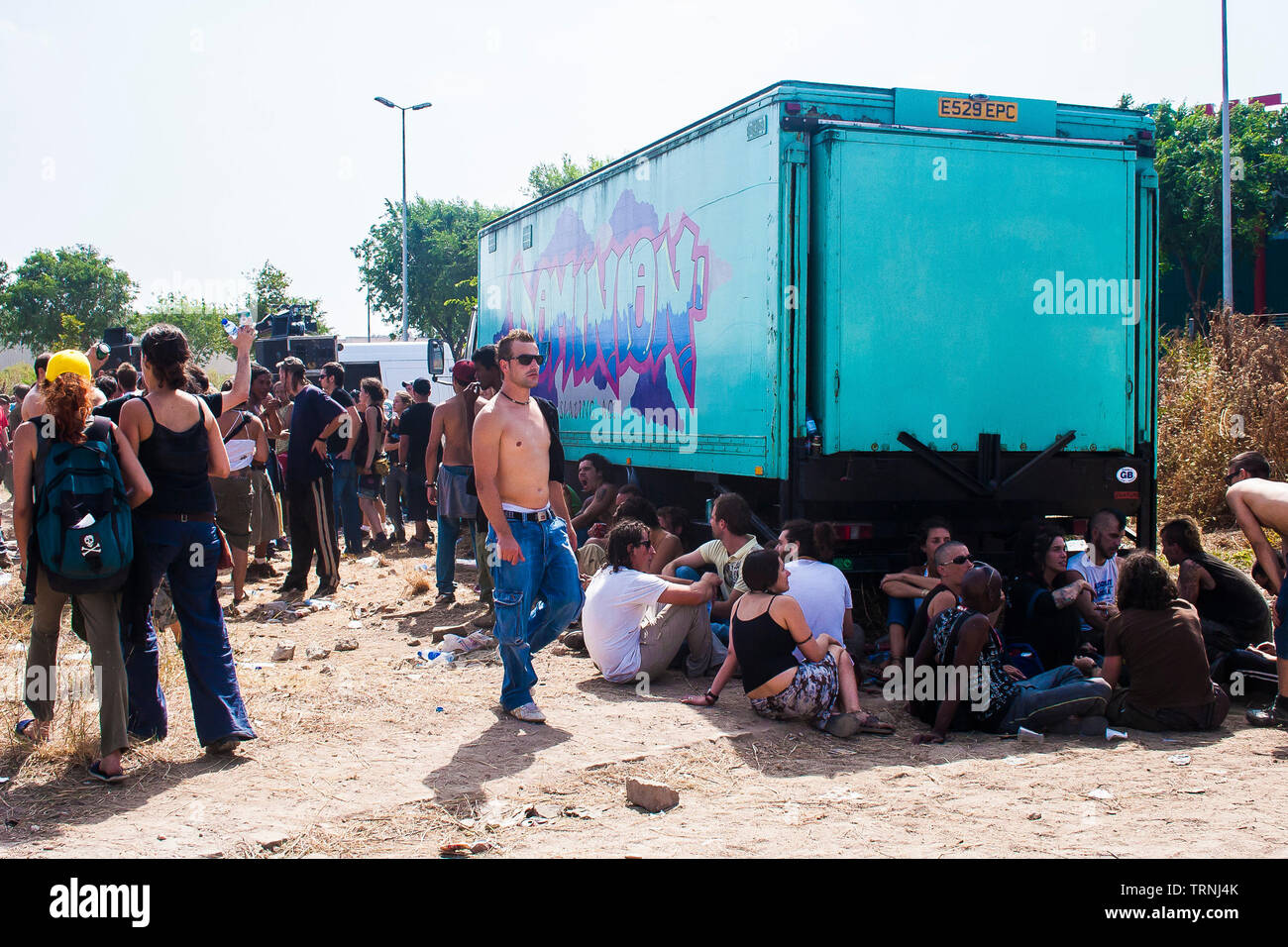Festival goers chilling out in the shade of a truck at Anti-Sonar free illegal squat party rave outside Sonar Festival, Barcelona, Spain Stock Photo