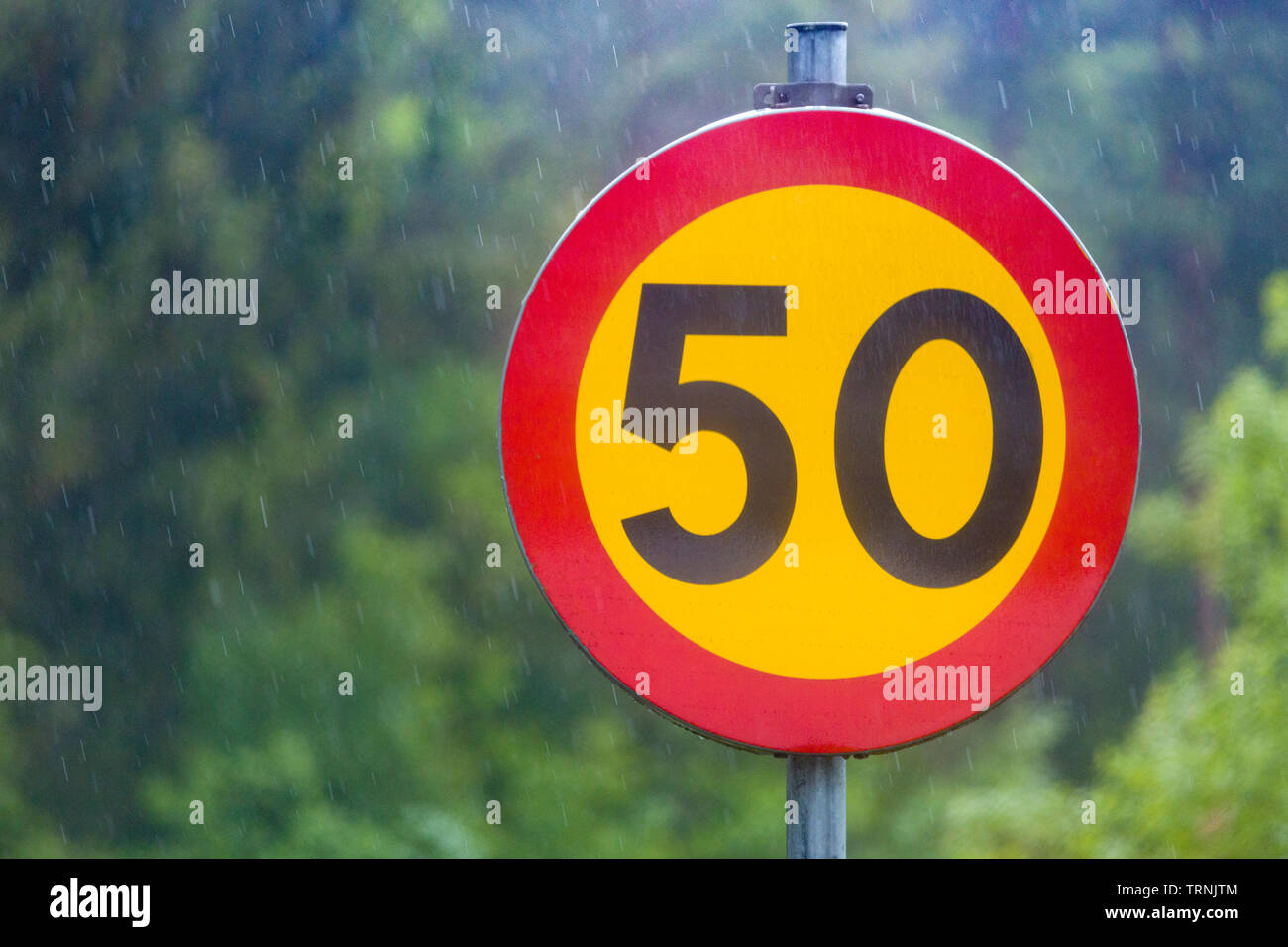 Close  up view of 50 km kilometres per hour speed traffic sign against beautiful out of focus blurry nature background Stock Photo