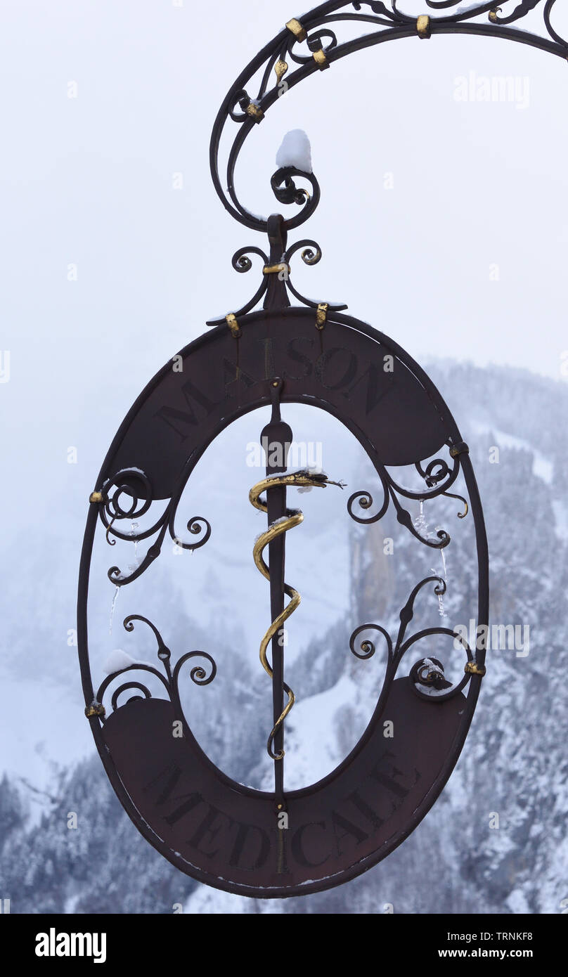A caduceus or rod of Asclepius  as a symbol of medicine in a sign outside an old pharmacy shop. Samoens, Haute Savoie, France. Stock Photo