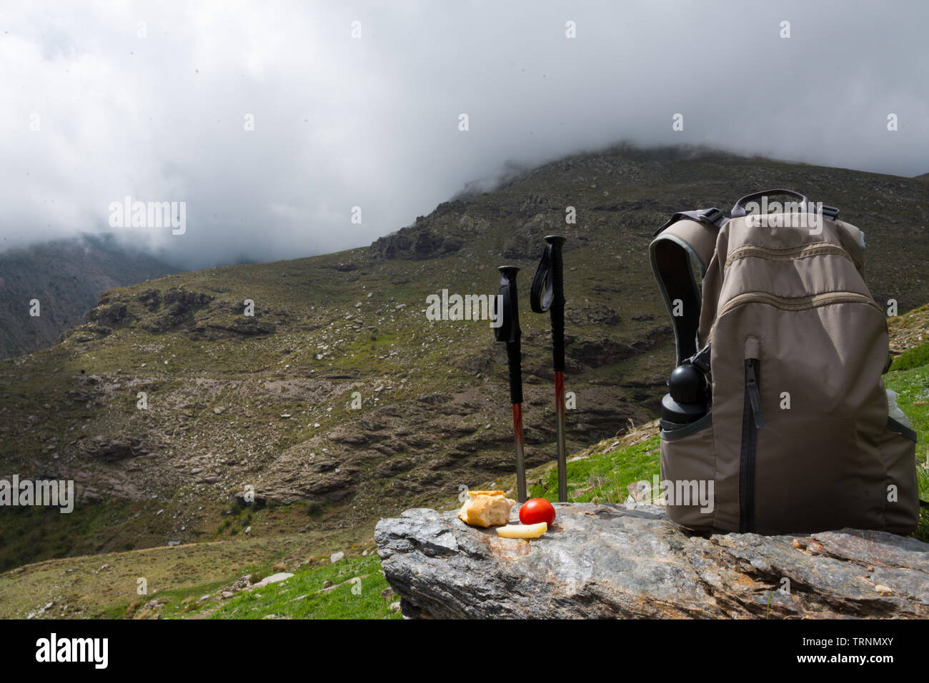 hiking sticks with lunch and backpack at mountain range in sierra nevada, spain Stock Photo