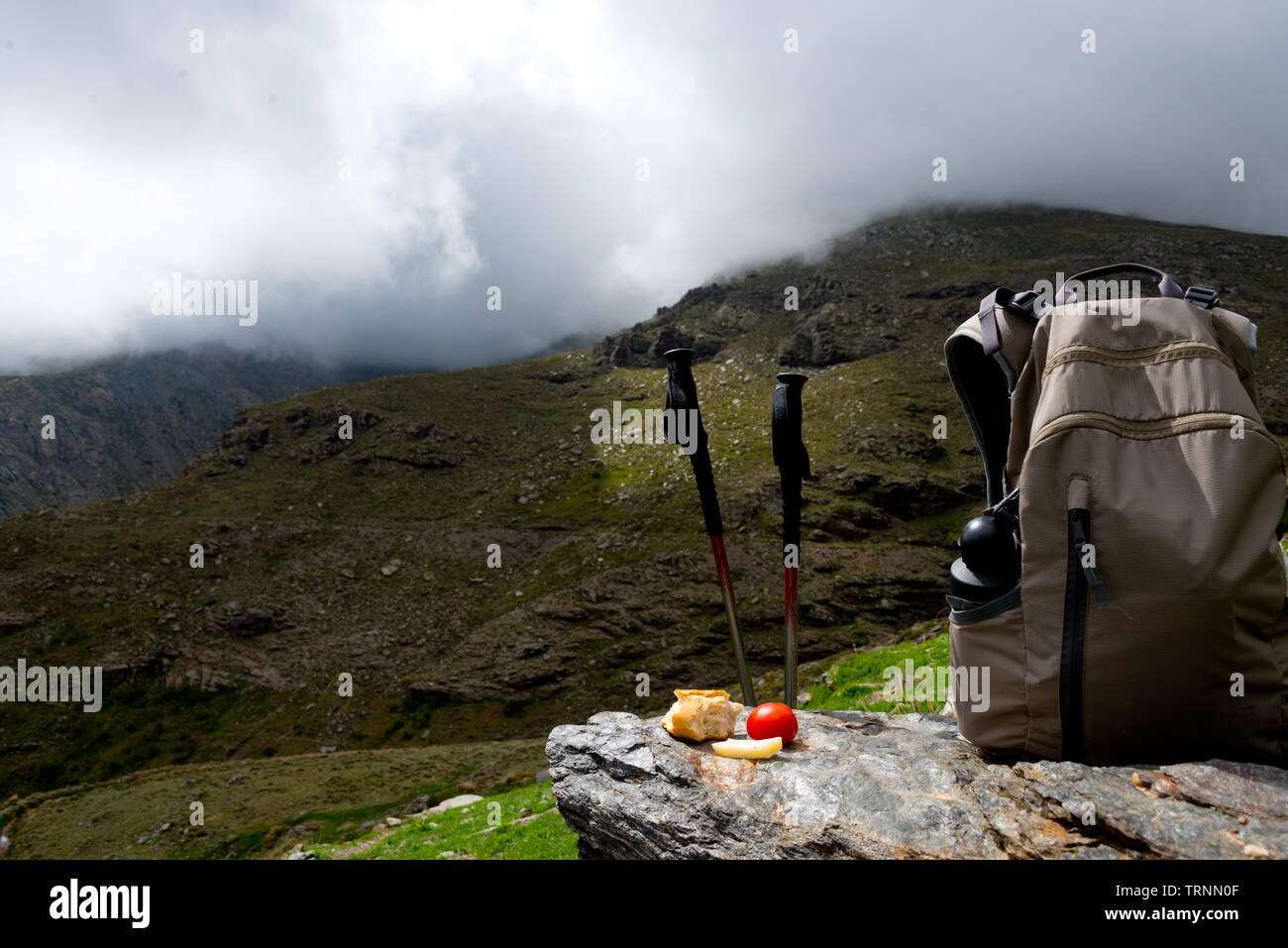 hiking sticks with lunch and backpack at mountain range in sierra nevada, spain Stock Photo