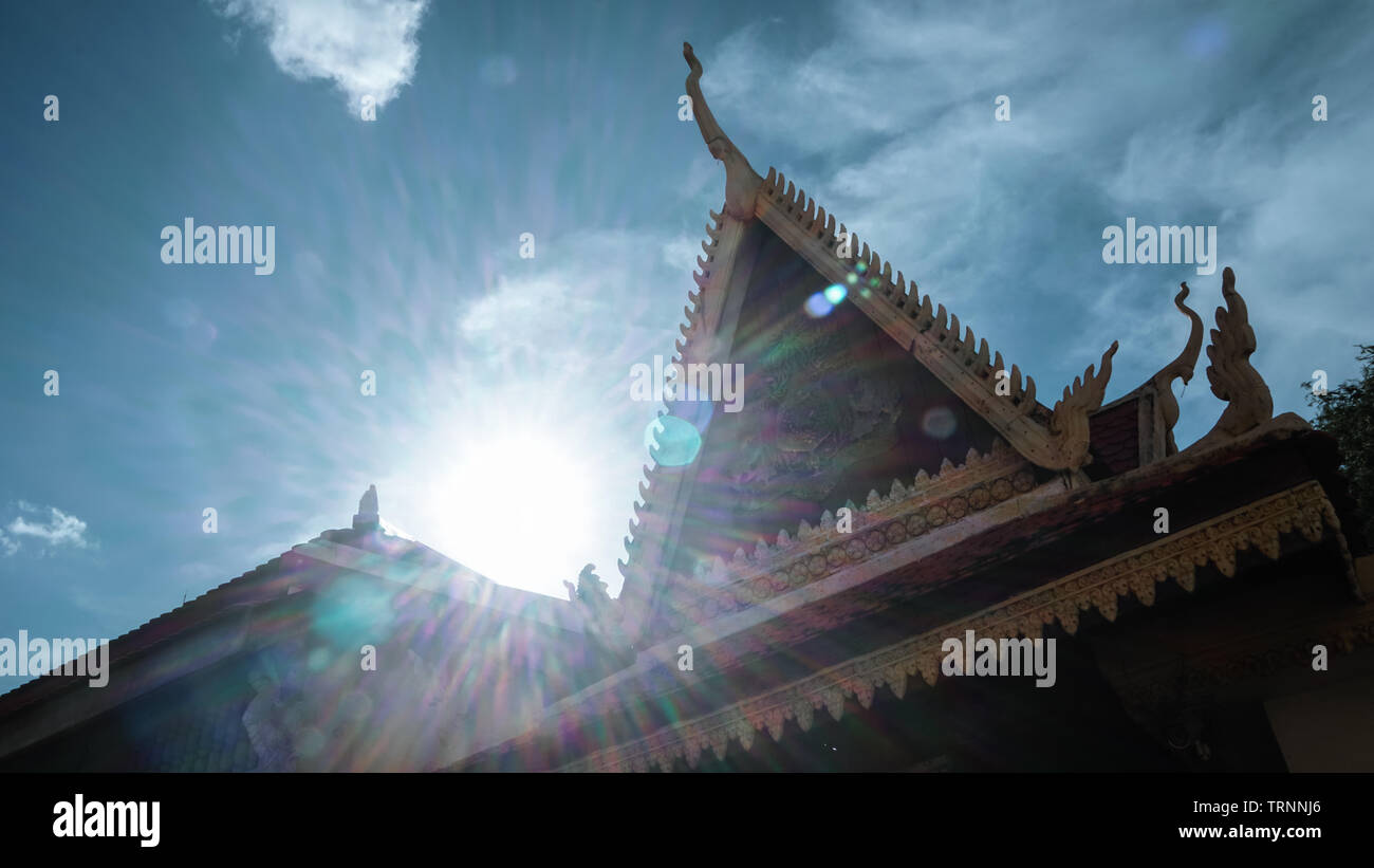 A powerful backlit shot of the roof at the Royal Palace and Silver Pagoda with clear blue sky at Phnom Penh, Cambodia. Stock Photo