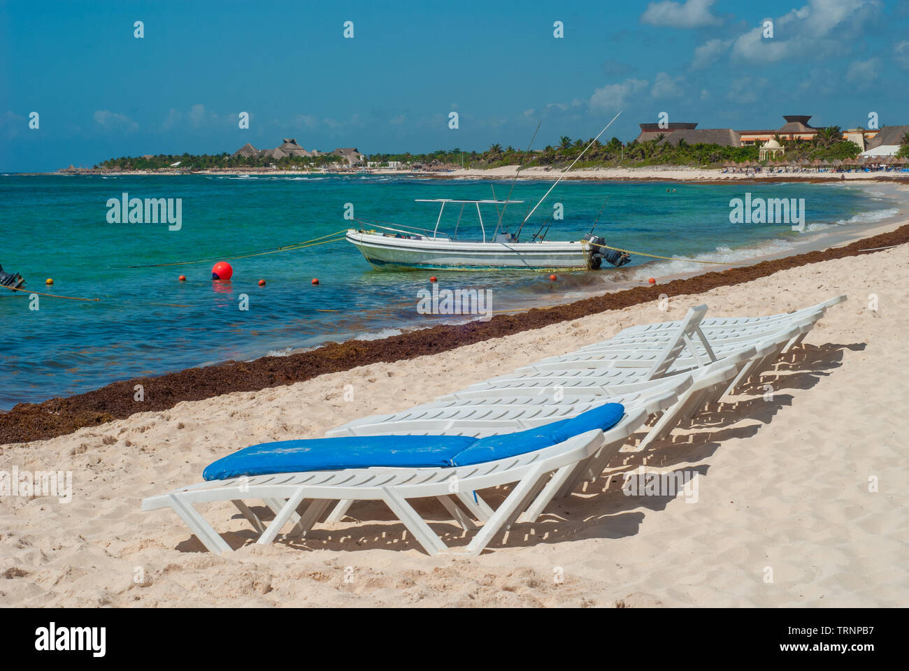Fishing boat and deckchairs taken on the beach of Tulum, in the Mexican Yucatan peninsula Stock Photo