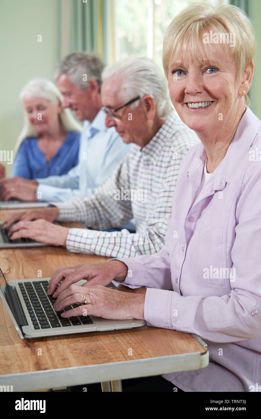Portrait Of Senior Woman With Tutor In Computer Class Stock Photo