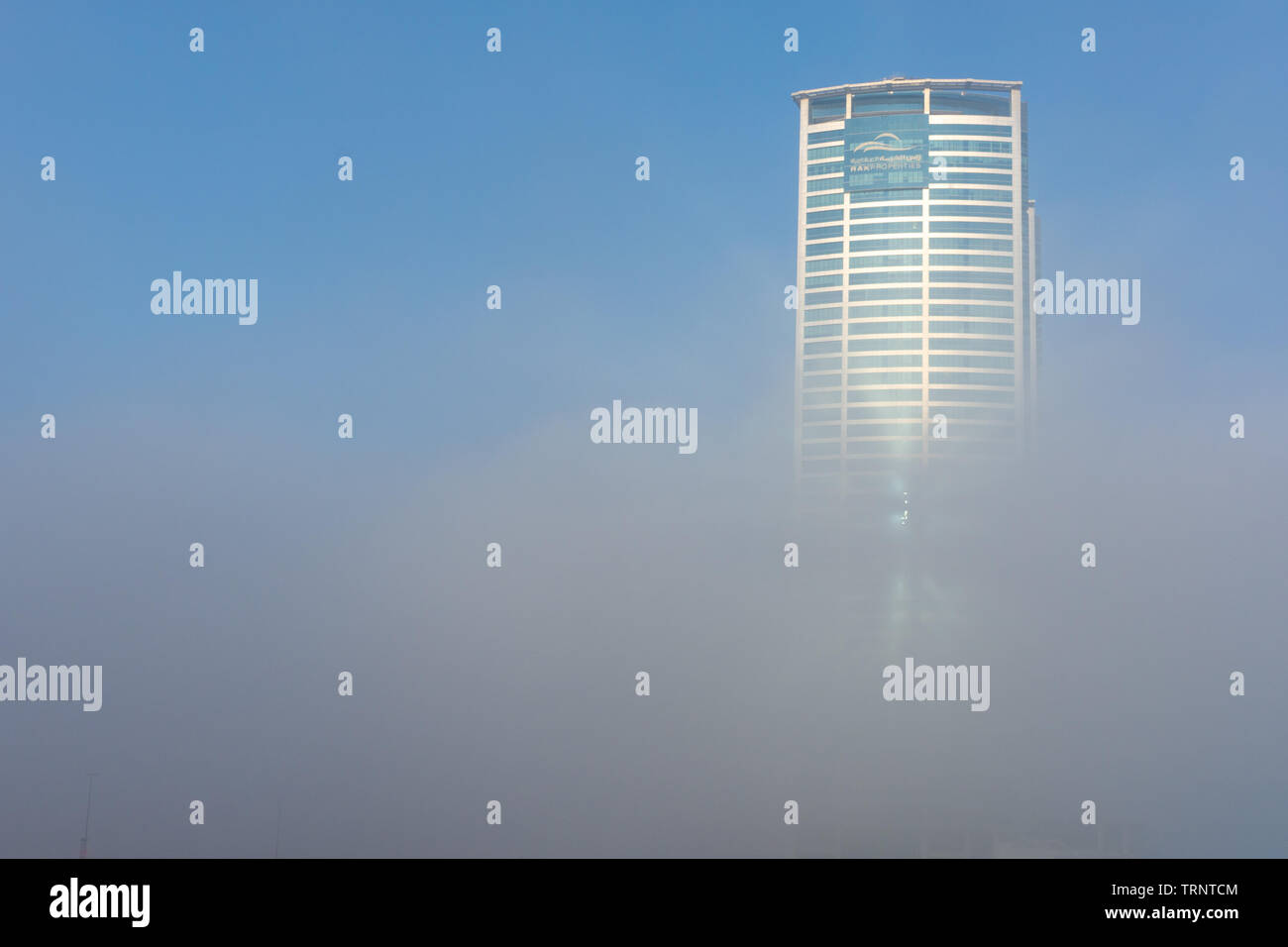 "RAK, RAK/UAE - 10/5/2018 Ras Al Khaimah City in the United Arab Emirates in the early morning fog. Julphur Towers, RAK Properties, in clouds. Stock Photo