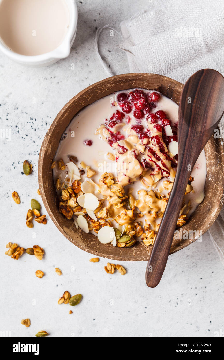 Homemade granola with cranberries and peanut butter in a coconut bowl