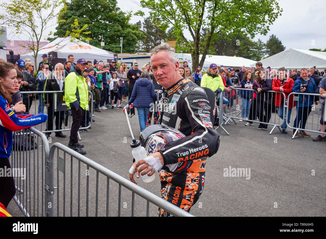 Michael Russell walks back to his team after his ride in the Senior TT race where he came 24th Stock Photo