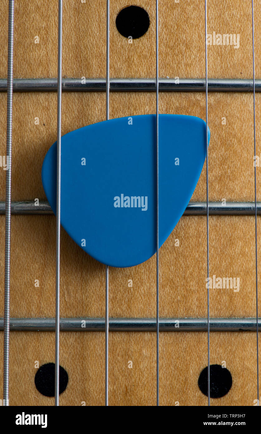 Close up of an electric guitar plectrum between the strings. Stock Photo