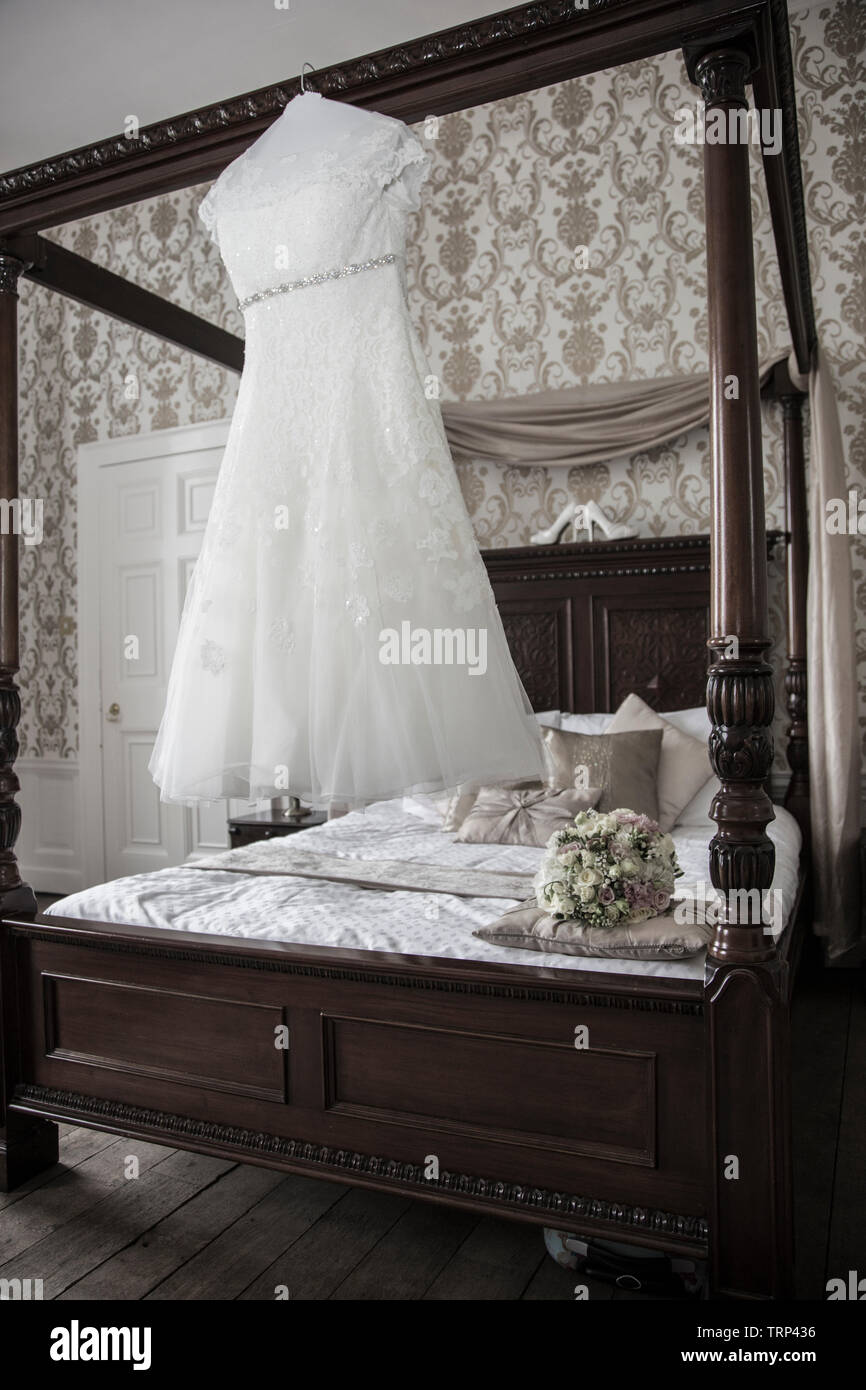 Brides white wedding dress hanging up waiting to be worn on her wedding ...