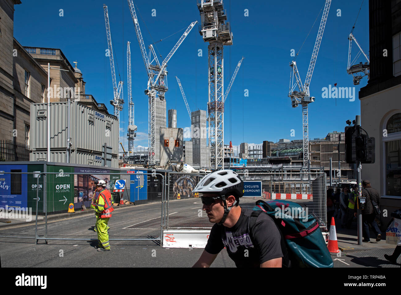 Cyclist passes the redevelopment of the St James Centre at the East End of Princes Street, Edinburgh, Scotland, UK. Stock Photo