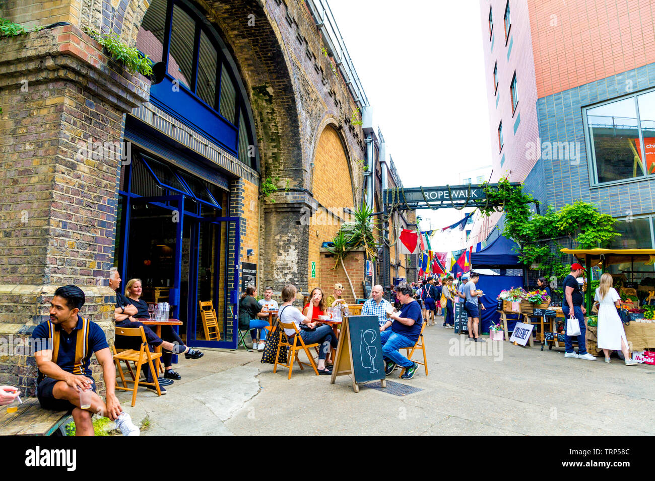 People sitting at outdoor tables at Maltby Street Market, London, UK Stock Photo